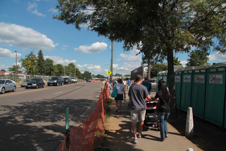 a group of people are walking next to the road