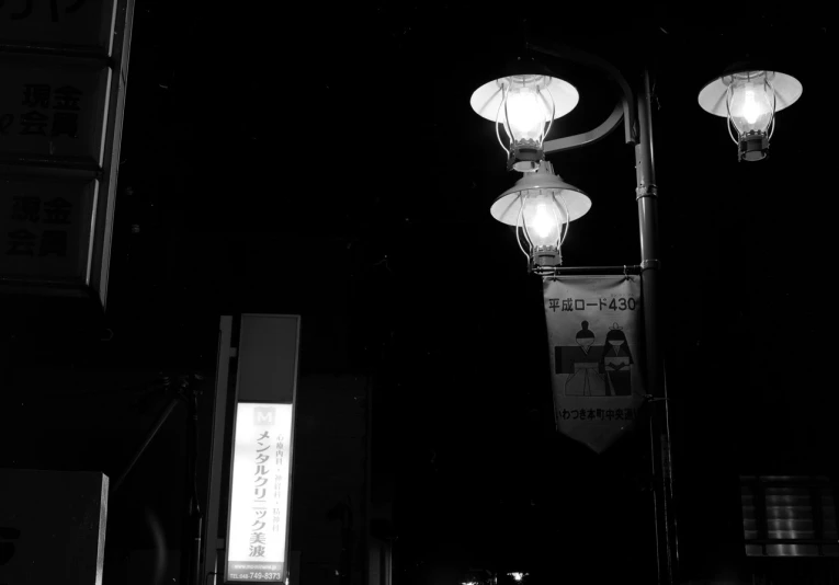 lanterns above an oriental street sign at night