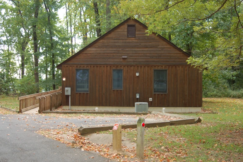 a brown cabin is surrounded by trees and foliage