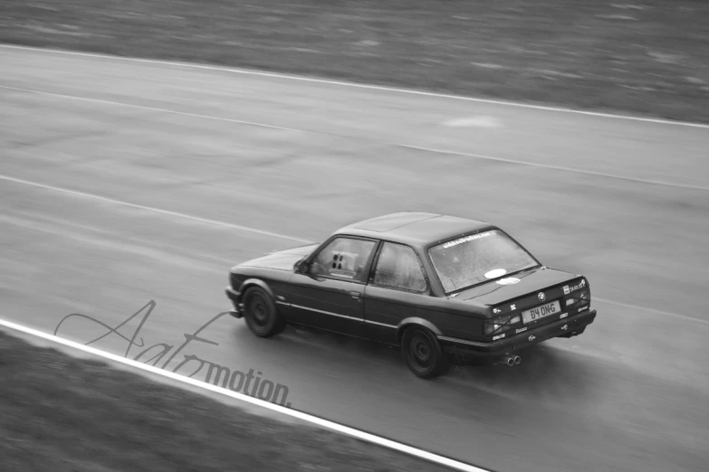 an old car drives along the road, with its doors open