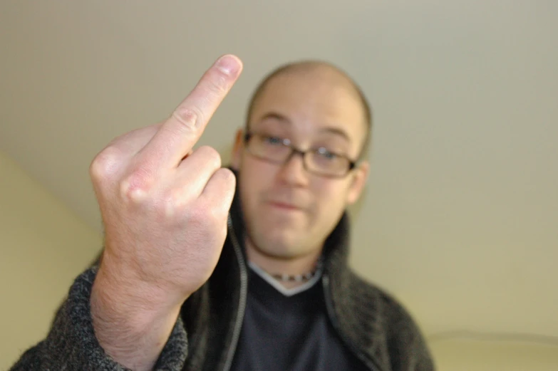 a man is showing the middle finger for the camera
