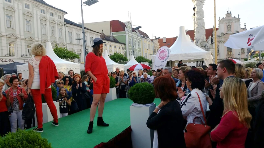 people gather in the streets to watch as models walk down the runway