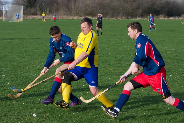 the two men are playing field hockey on the field