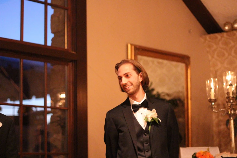 the groom is standing at the entrance to his wedding