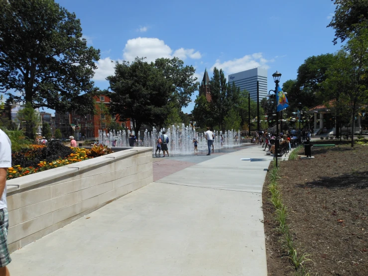 a lot of people in the park near a fountain