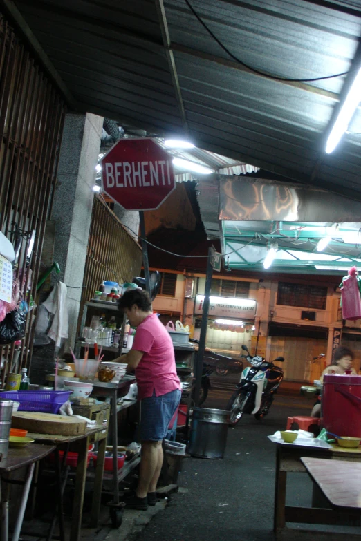 a woman prepares food in the dining area of a commercial food court