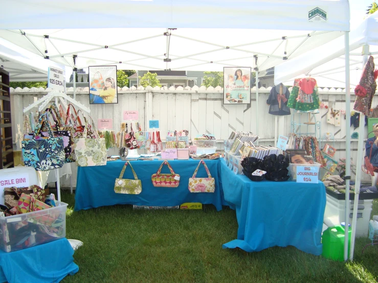 a tent covered in tables with bags and purses