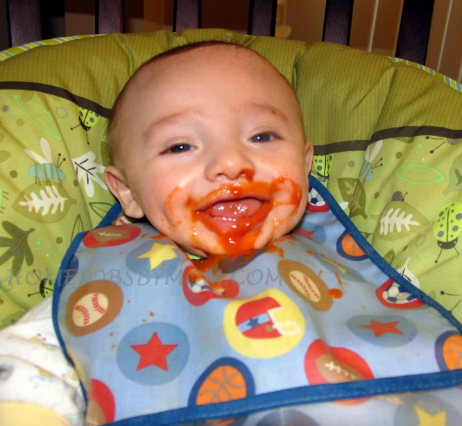 an infant is having food on his mouth