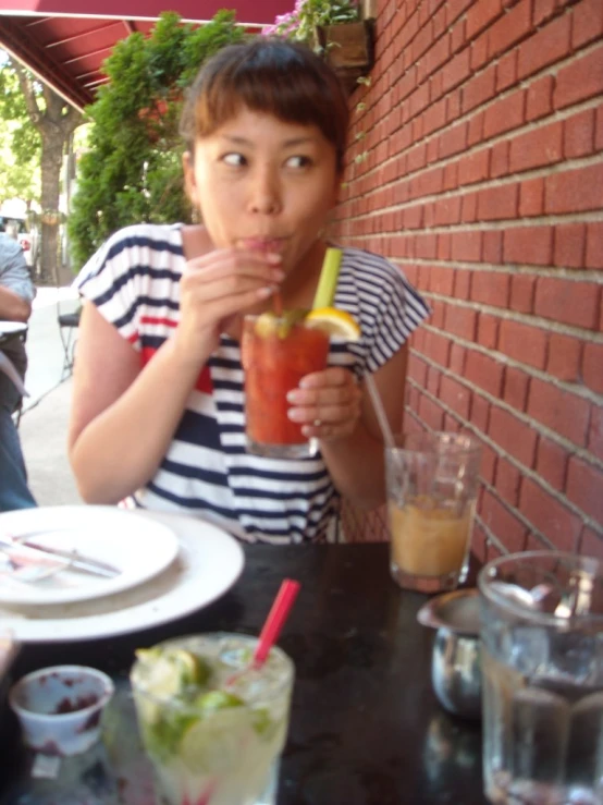 a woman sits outside drinking her drinks