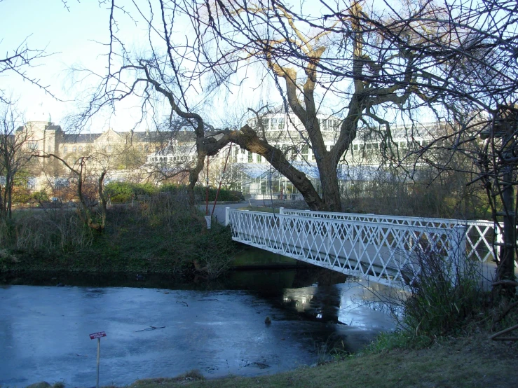 an old white bridge crossing a river in winter