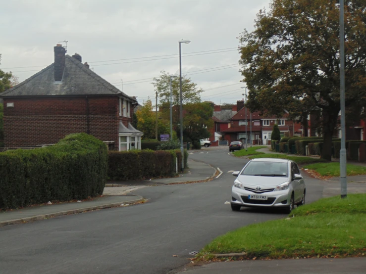 a car driving down the road near a grassy area