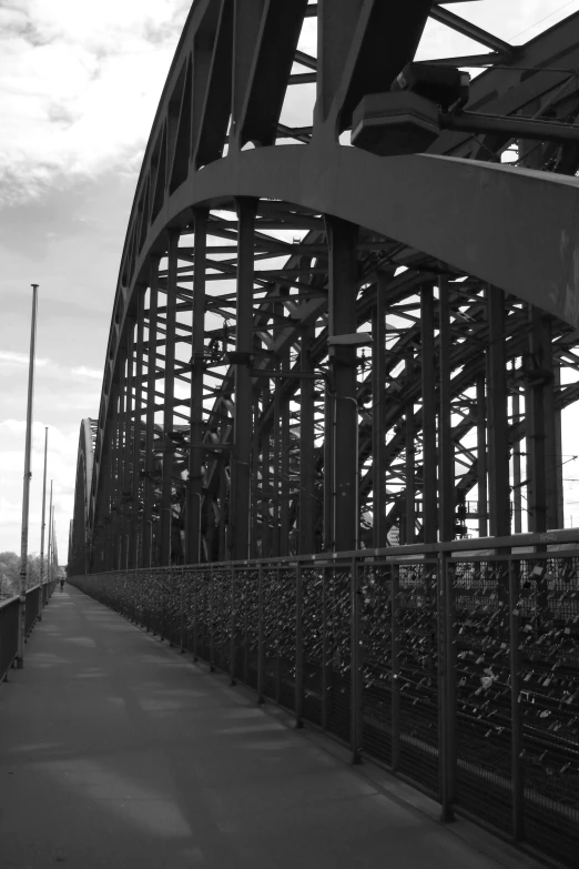 the view of a large metal bridge under a cloudy sky