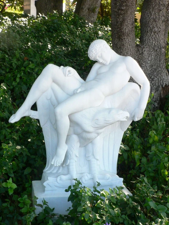 two statues sitting in the middle of shrubbery
