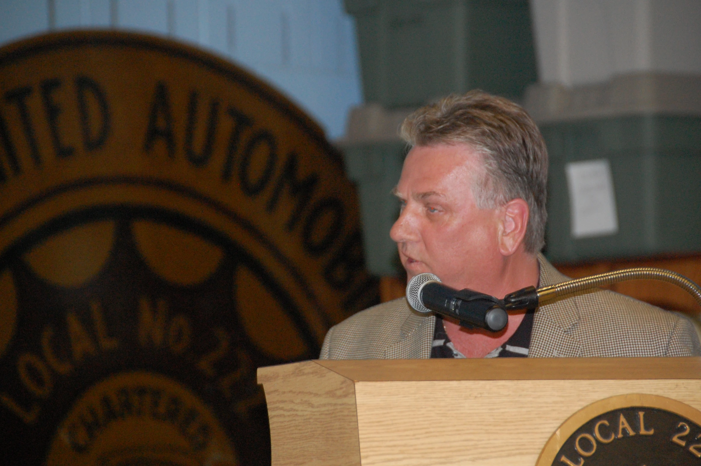 a man sitting at a podium talking into a microphone