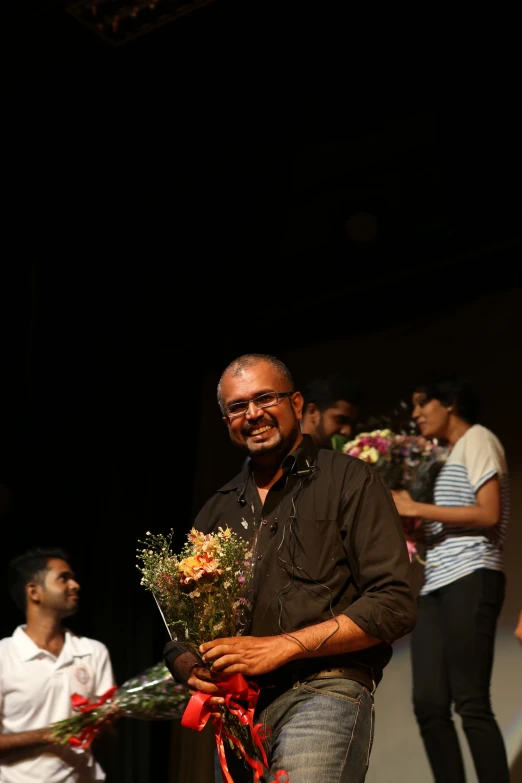 a man with many flowers and people in the background