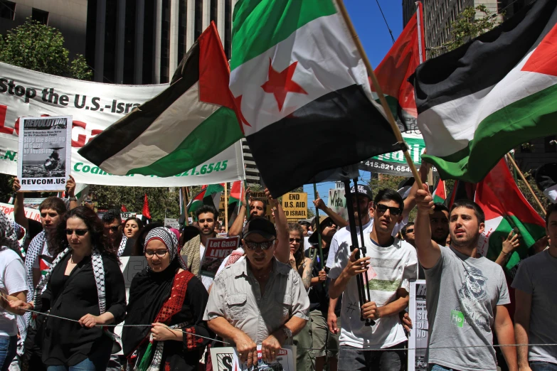 some people are marching on a street holding flags