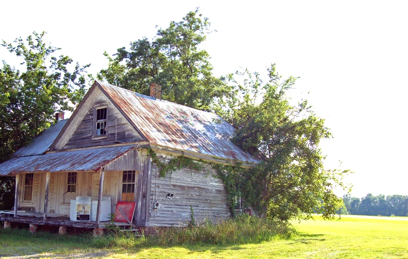 an old house with no windows sits in a field