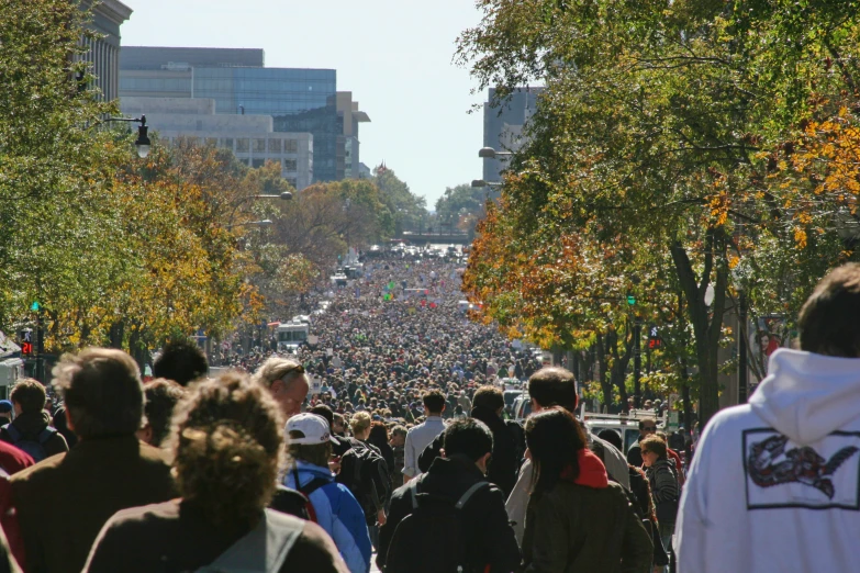 people are walking down the city street on an autumn day