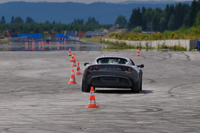 a black sports car is driving through some cones