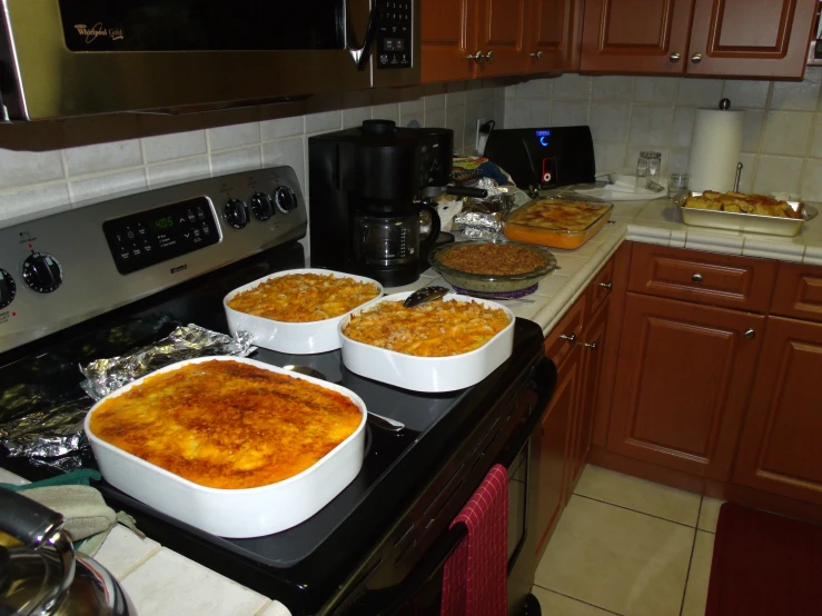 the three dishes of macaroni and cheese are cooking in the kitchen