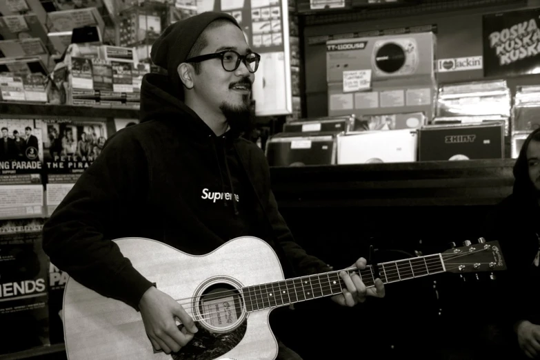 a person holding a guitar in front of a store