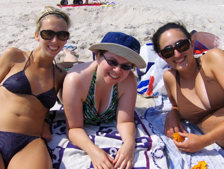 four women lying on the beach on a towel