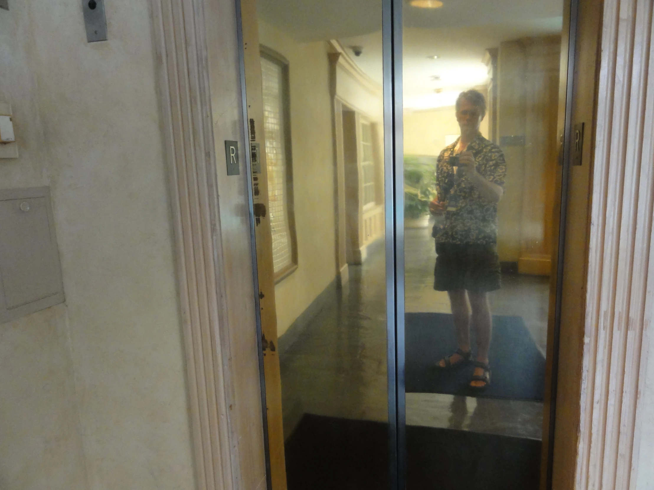 a woman standing on a tile floor in front of glass doors