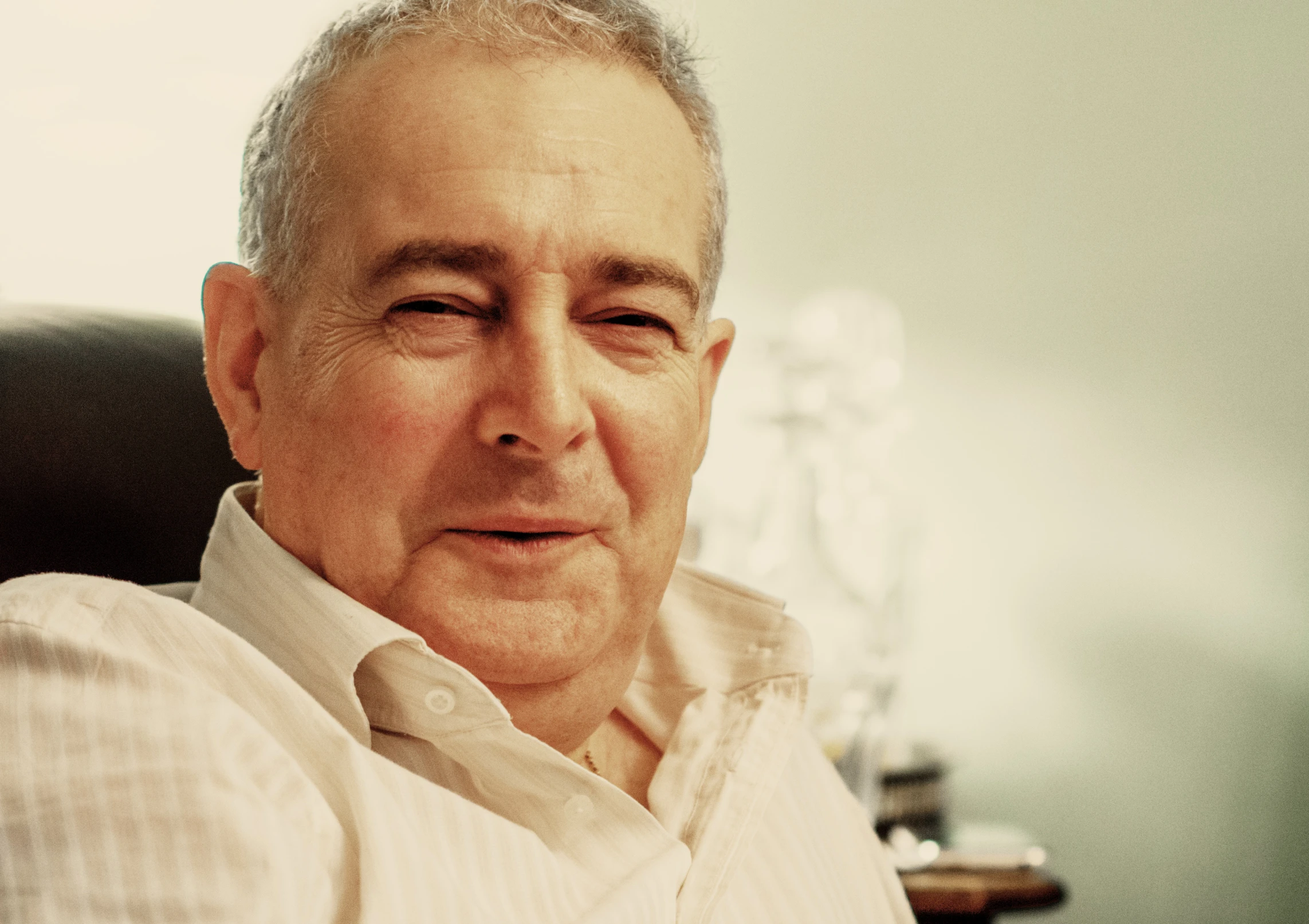 a man wearing a white shirt is sitting in a chair