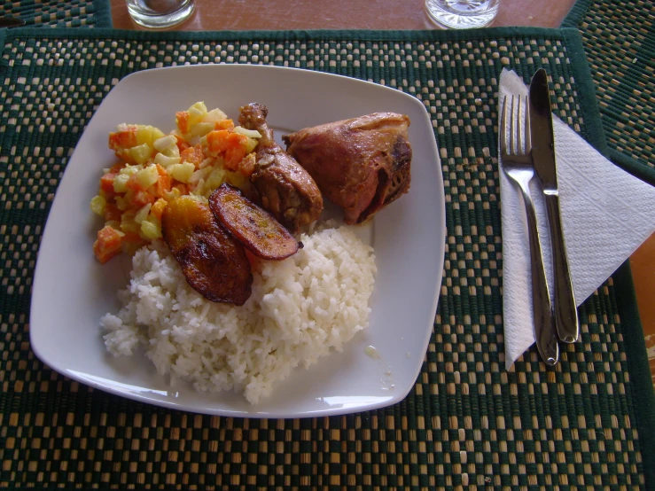 a white plate topped with rice and vegetables