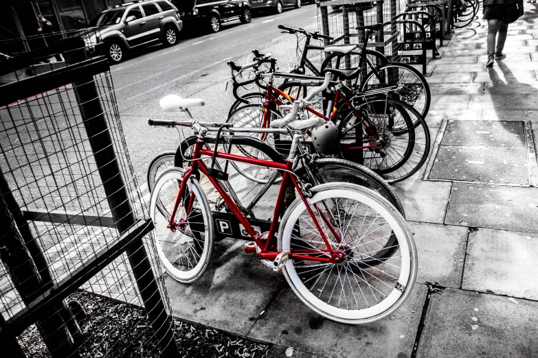 a bunch of bicycles are parked at the end of a city sidewalk