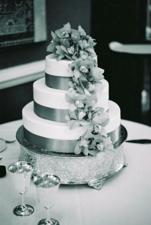 the tiered cake has a bunch of flowers on top