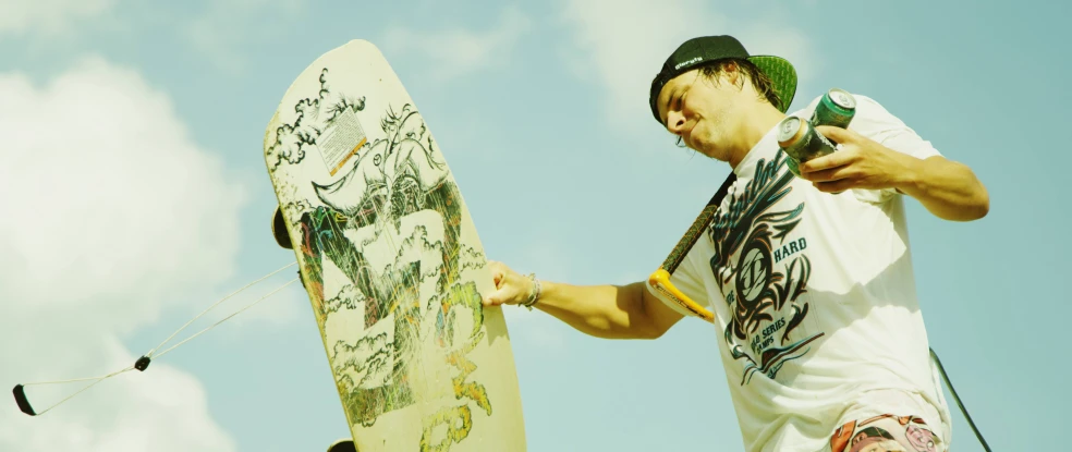 a man holds his snowboard up to the sky