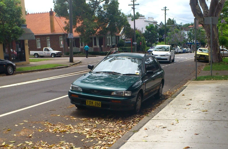 car parked on a street lined with leaf