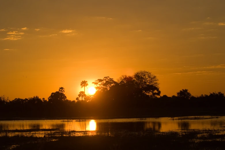 the sun setting in the background over some water