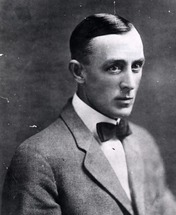 a black and white po of a man wearing a suit with a bow tie