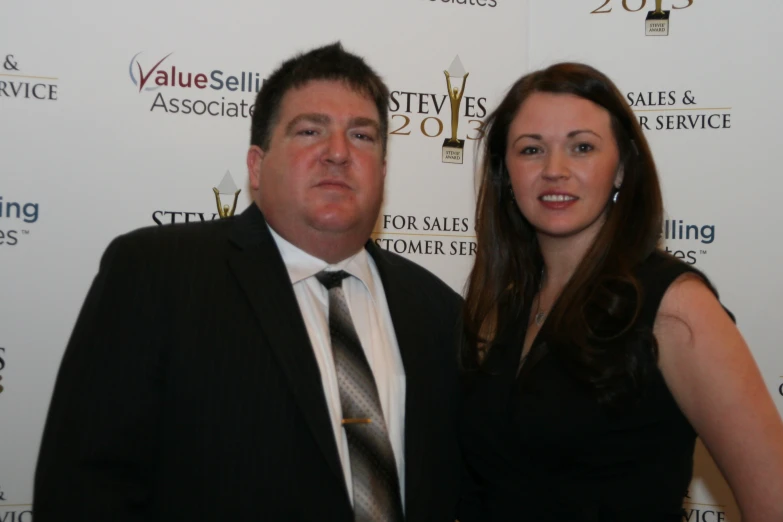 a woman and man in front of an award red carpet