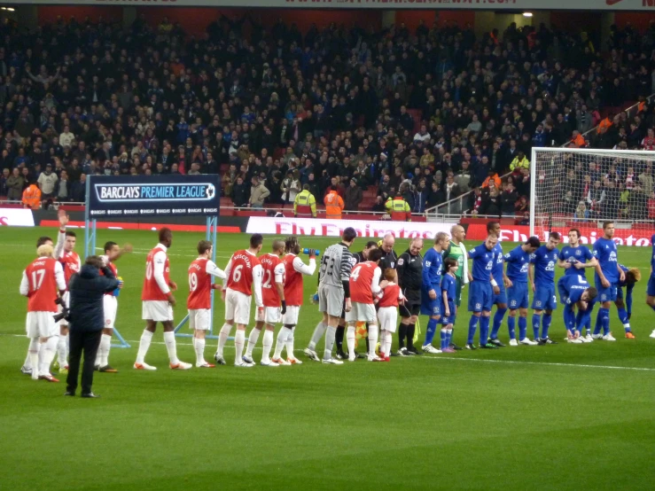 a group of people standing around a soccer field