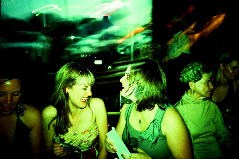 a group of women sitting next to each other in a dark room