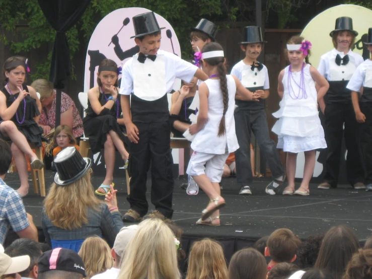 two people stand on stage and sing to an audience