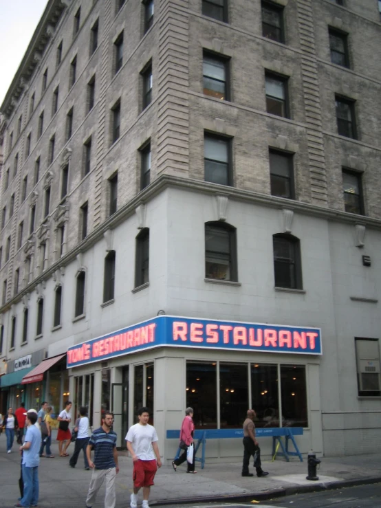 people stand on a ledge near a building