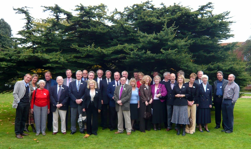 a group of older people standing next to each other in the park