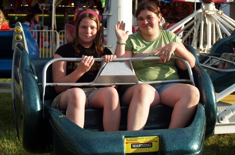 two girls in the park ride on a roller coaster