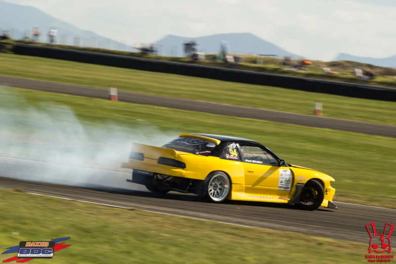 a yellow car is driving on a track with smoke coming out