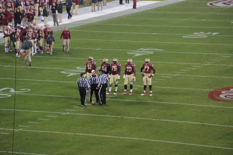 a group of people standing on top of a football field