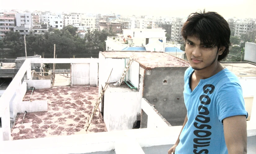 a man on the roof of a building looks towards the camera