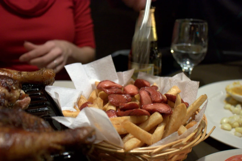 a basket of fries sits next to some meats