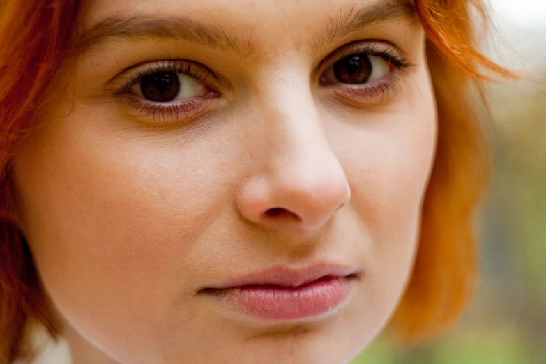 a close up image of a woman's face with hair up