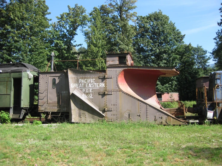 an old train is sitting on some grass