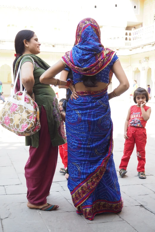 two women in brightly colored clothing are talking