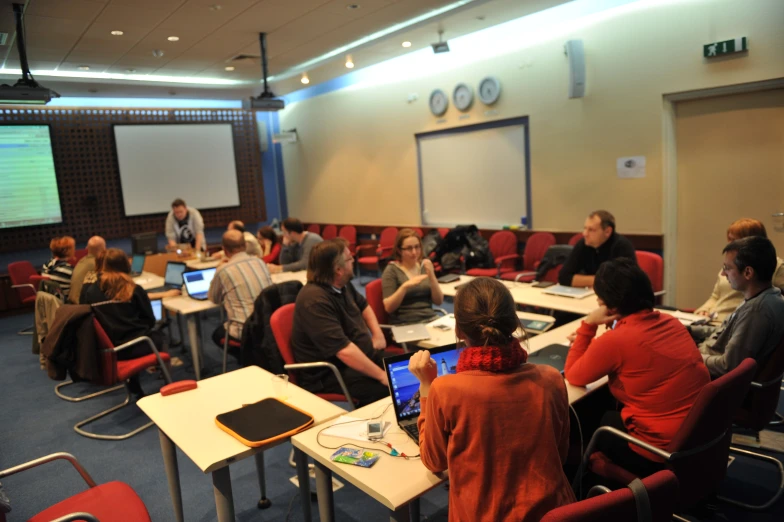 people at table with laptops on it in a conference room